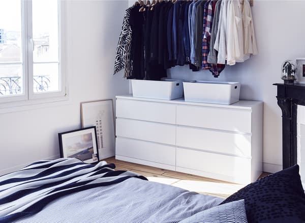 Commode à 6 tiroirs et vêtements suspendus dans la chambre à coucher