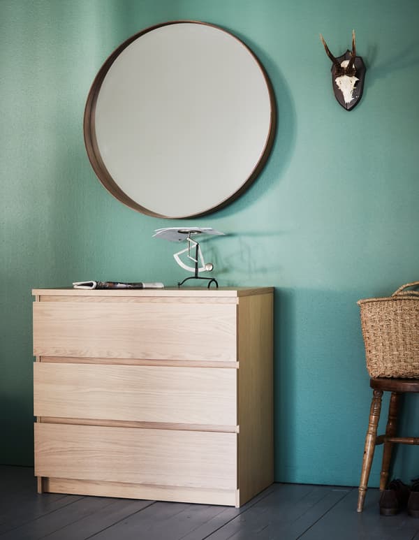 Commode appuyée contre un mur dans une chambre à coucher.