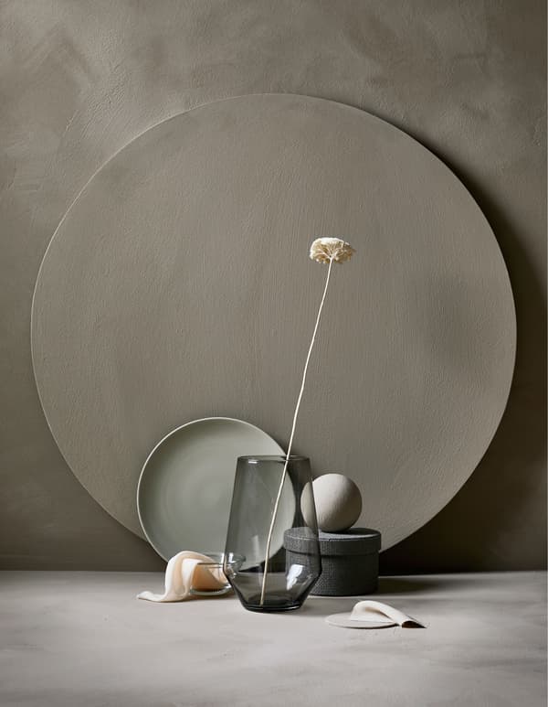 Composition comprenant un vase en verre et une fleur, un plateau, une boîte de rangement et des tissus dans des couleurs similaires