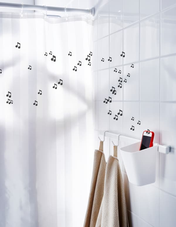 Contenant plastique placé à proximité de la douche et téléphone intelligent diffusant de la musique.