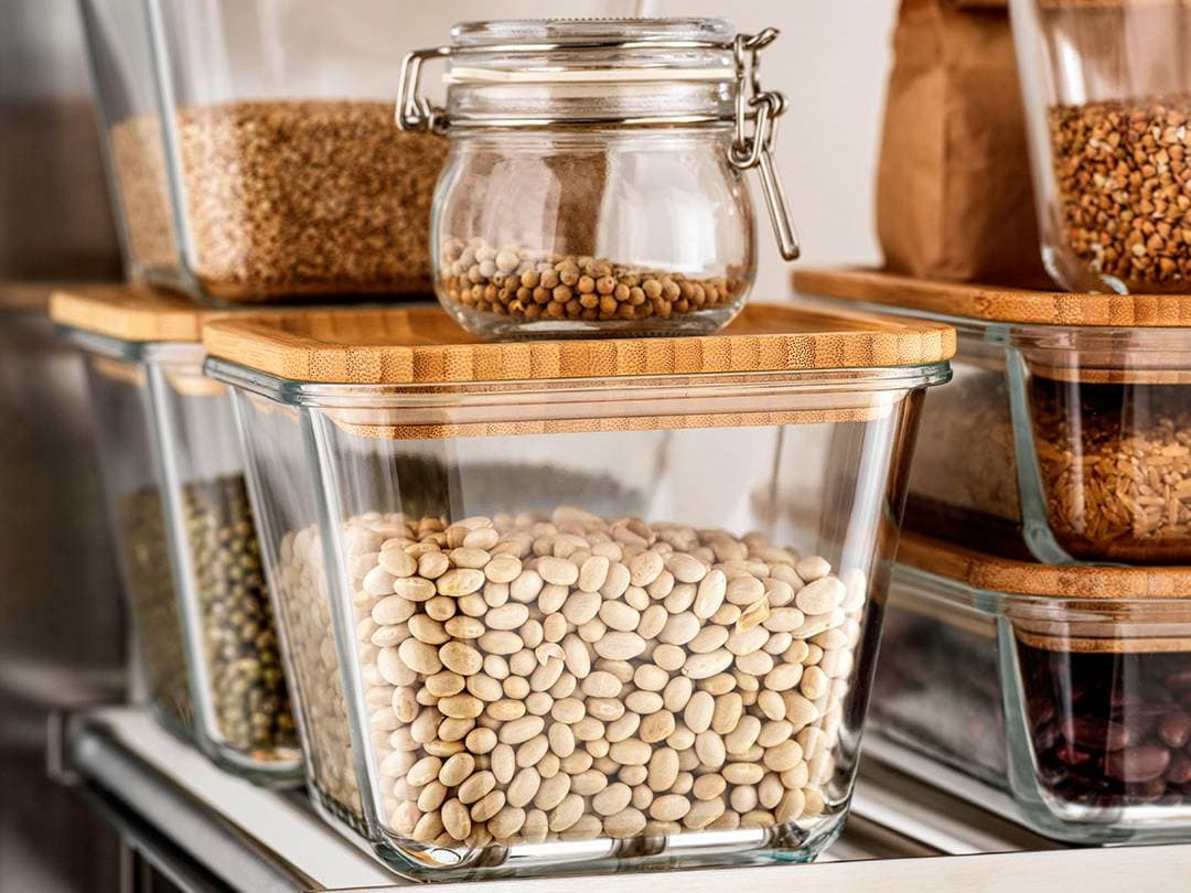 Contenedores de alimentos IKEA 365 de vidrio, con legumbres y semillas en su interior.