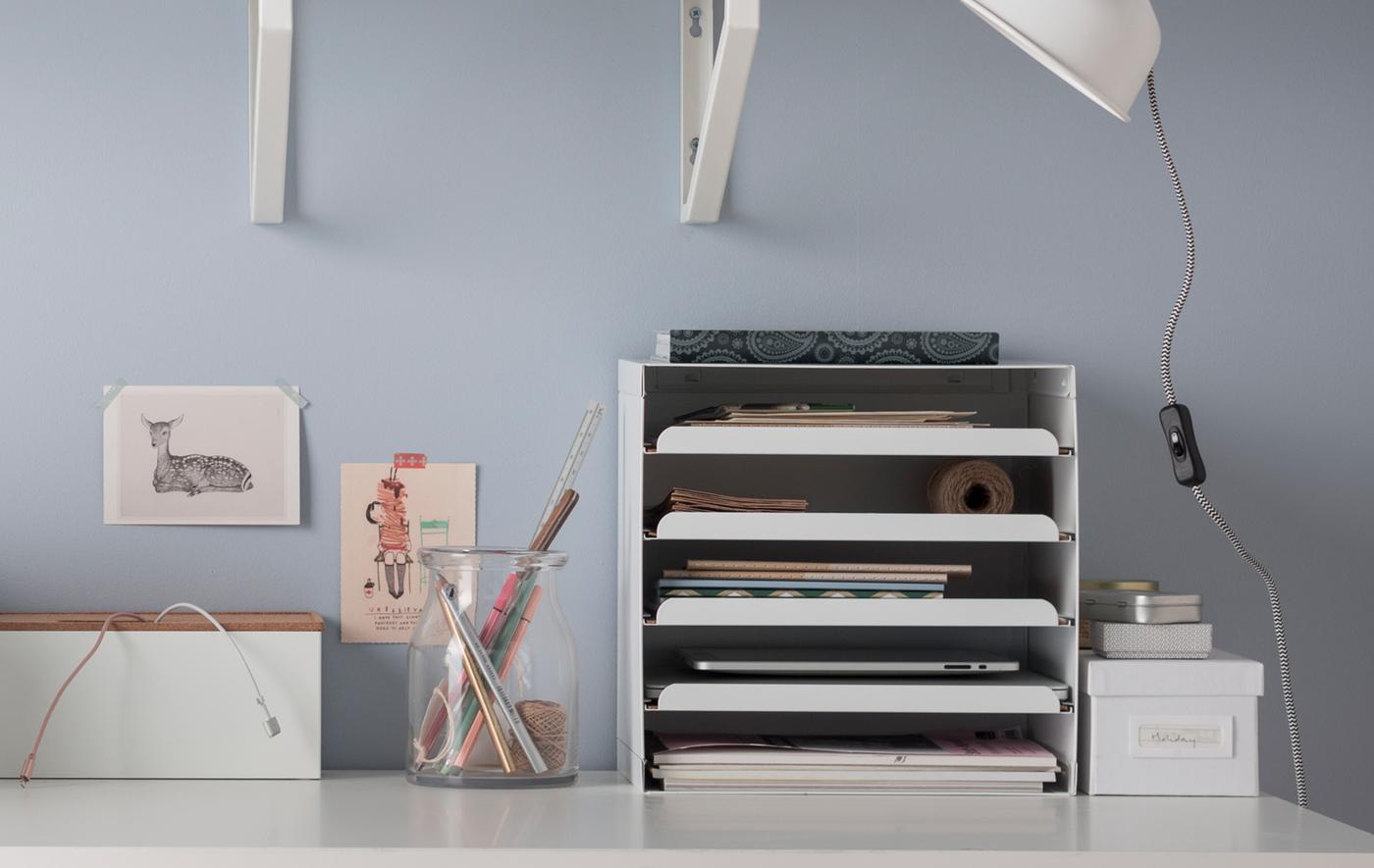 Corbeilles à courrier, étagères murales, boîtes, poste de charge et porte-crayons font équipe pour libérer ce bureau tout blanc. En voilà de bonnes idées pour faire de la place!