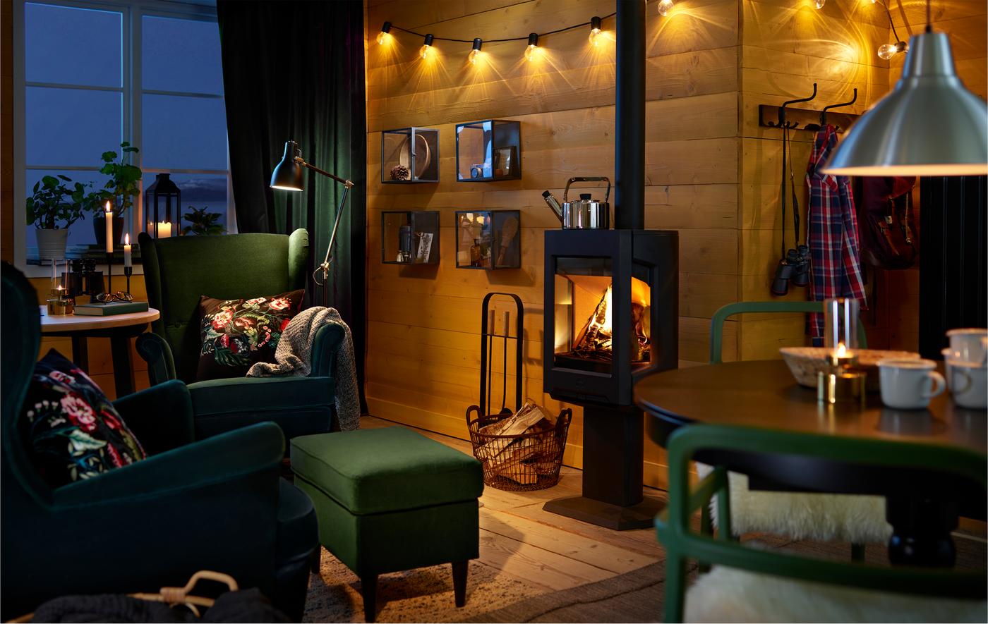 Cosy room with table and comfortable chairs, arranged around a warm open-stove.