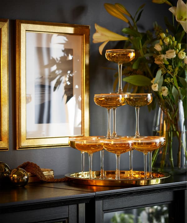 Coupes STORHET remplies de champagne et installées en pyramide sur une table noire.