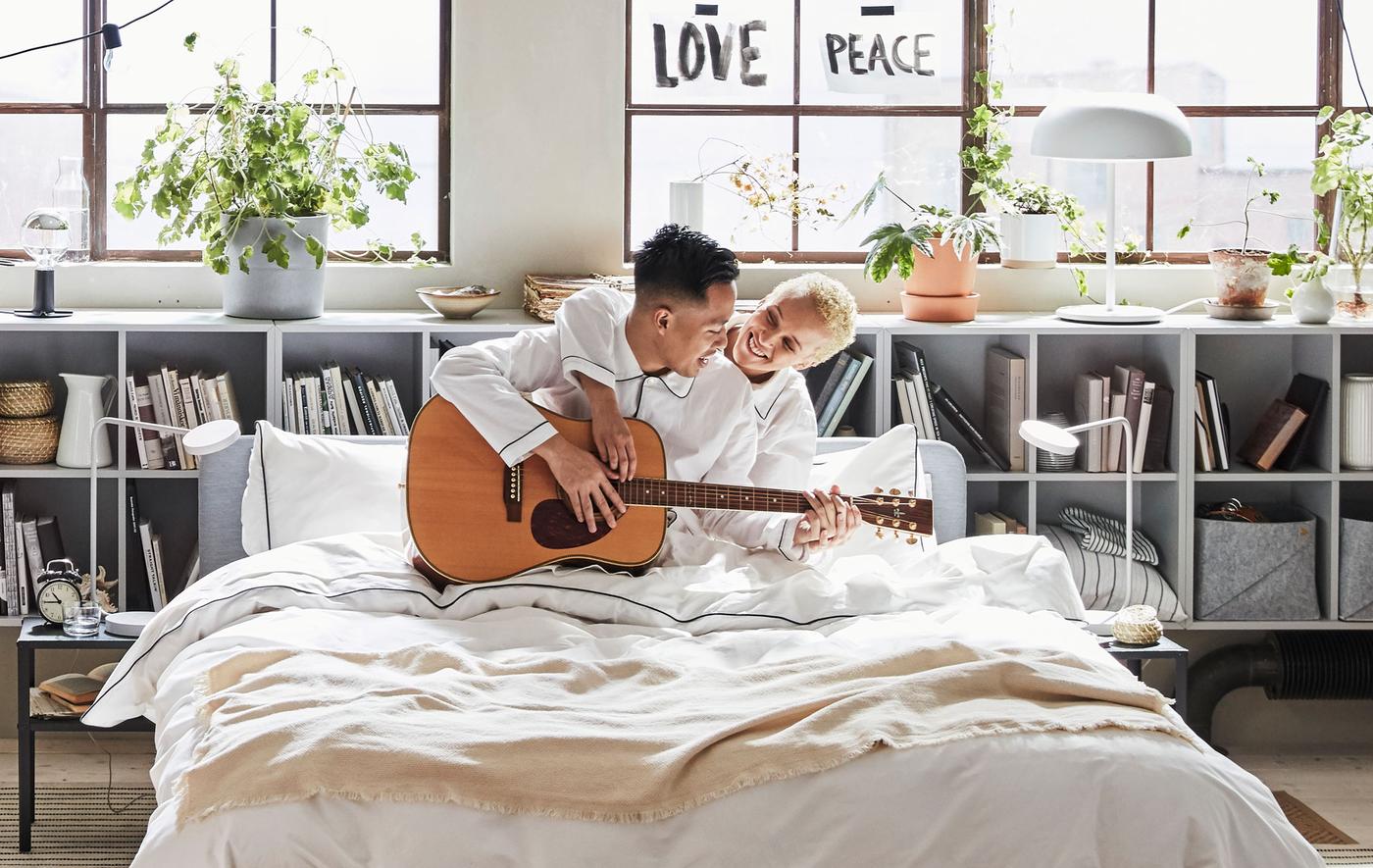 Couple au lit avec guitare, dans une chambre de style loft.