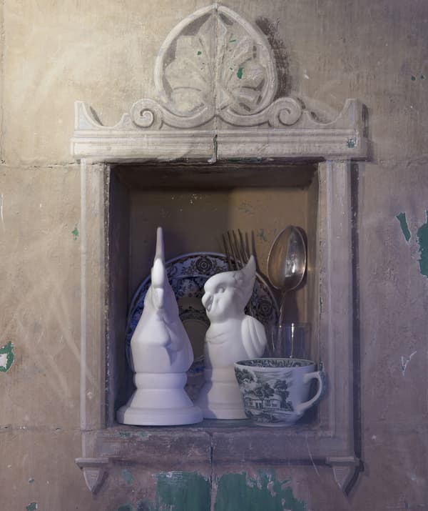 Couple d’oiseaux blancs décoratifs et vaisselle, dans une niche.