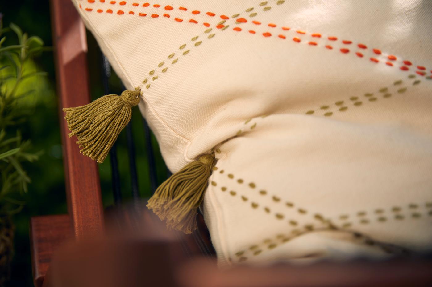 Coussin beige clair avec rayures et pompons