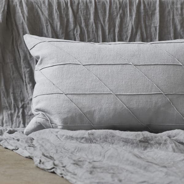 Coussin gris avec piqûres en relief.