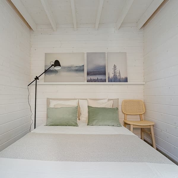 Cozy bedroom with green pillows and nature-themed wall art