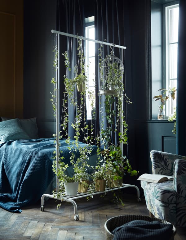 Create a lush room divider! Use a clothing rack such as IKEA RIGGA. Place pots on the rack at the bottom or use string to attach the pot to the frame. Fasten a few branches to the top bar with thread.