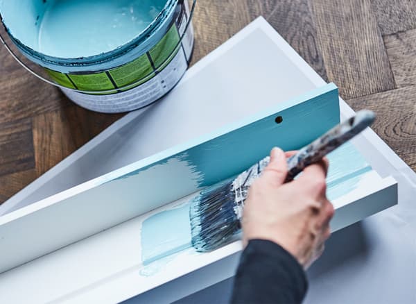 Create a photo frame wall with big impact! Just paint a couple of picture ledges in the same hue as your wall! Why not try IKEA MOSSLANDA picture ledge? Here we painted them in a bold turquoise hue for a uniform living room look.