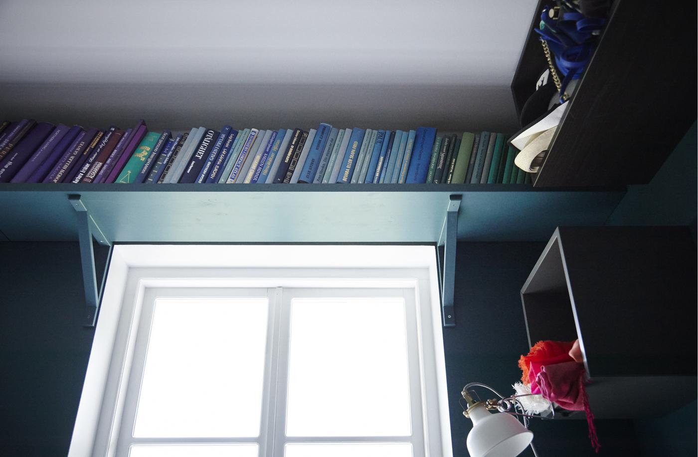Create easy extra storage for books on a shelf above your window.