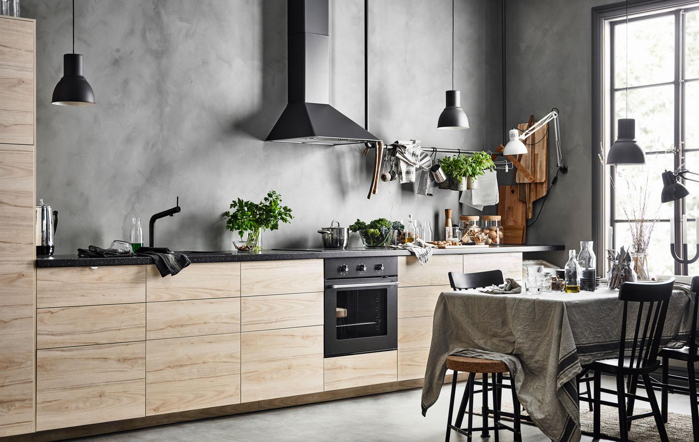Cucina lineare con ante frassino con lo sfondo di una parete grigia effetto cemento - IKEA.