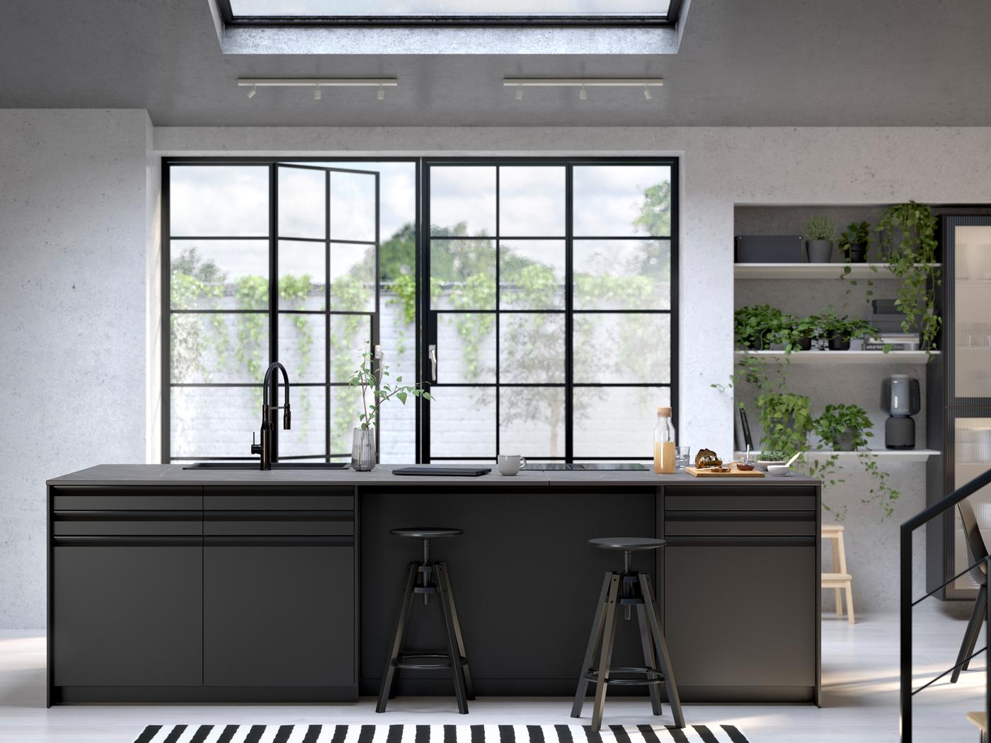 Cuisine avec portes UPPLÖV anthracite, tabourets de bar DALFRED noirs et plaque de cuisson à induction avec hotte intégrée FÖRDELAKTIG.