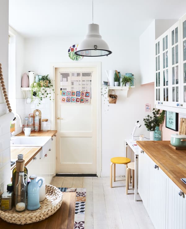 Cuisine blanche avec accessoires dans des couleurs pastel.