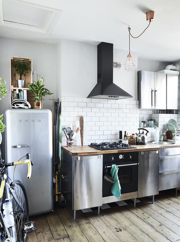 Cuisine en acier inoxydable avec sol en bois.