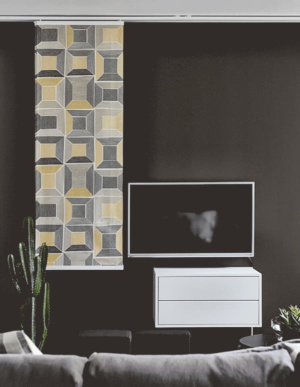 Curtains from IKEA are an easy option for TV concealment. Use curtain rails on the ceiling to hang panels of fabric like BIRKET that has yellow, white, black and brown squares for a modern look. Slide them over when it’s TV time.