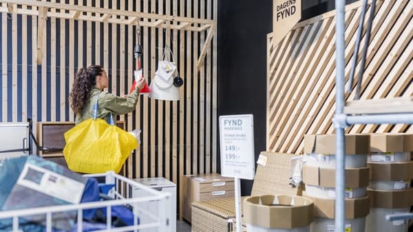 Customer shopping in an IKEA as-is department with a yellow bag on her arm.