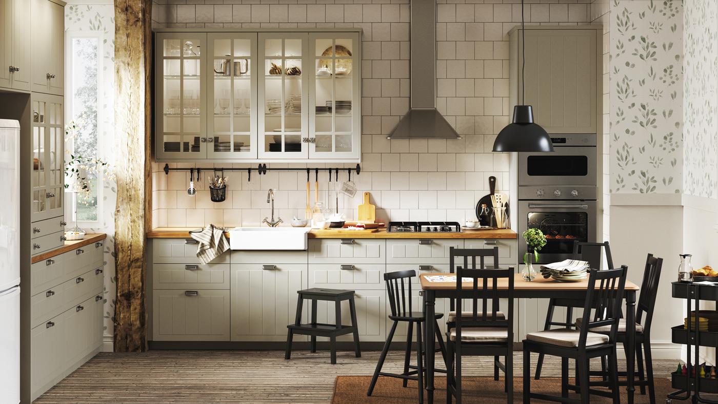 Dapur gaya tradisional dengan kabinet berwarna kuning air, jubin berwarna putih, lantai kayu, kertas hias dinding corak bunga dan set ruang makan berwarna hitam.