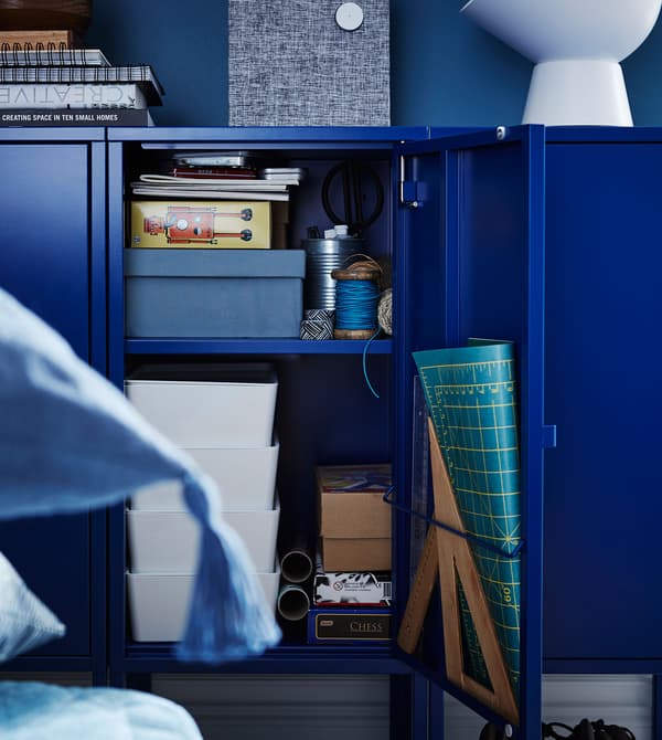 Dark blue LIXHULT metal cabinets filled with various organizational items.