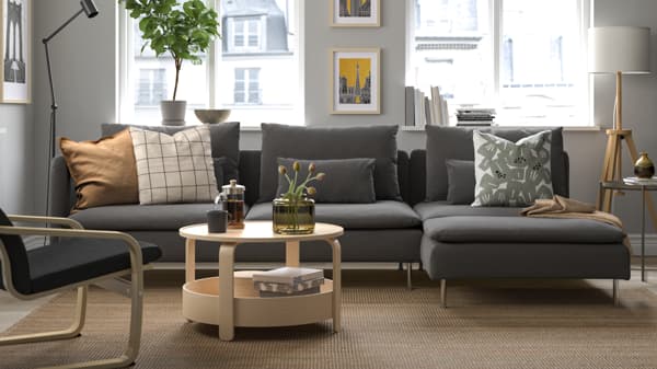 Dark grey SÖDERHAMN modular sofa in modern living room with monochrome accents, wooden coffee tables, and patterned cushions.