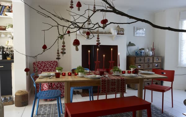 Decorations hang from a branch over a nature-inspired festive dining room table.