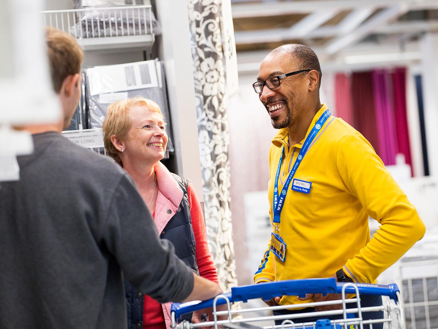 Decorative image of an IKEA co-worker assisting customers in store