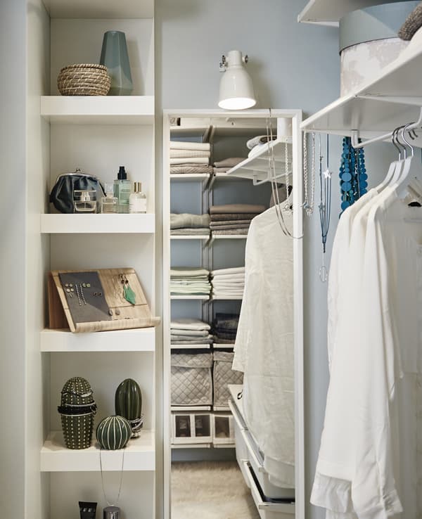 Dedicate one wall of your walk-in closet as a vanity space, complete with a shelving unit, full-length mirror and a basket for haircare items.