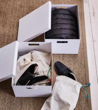 Des boîtes de rangement en carton accueillent vêtements et chaussures