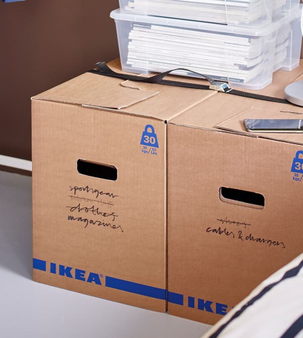 Des boîtes transparentes remplies de papiers, placées au-dessus de boîtes JÄTTENE sur lesquelles sont écrites différentes choses.