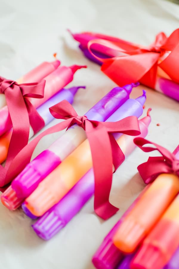 Des bougies colorées de bricolage attachées par des rubans, prêtes à être offertes en cadeau