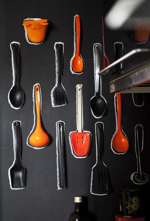 Des murs en tableaux noirs transforment les ustensiles en tableau coloré dans la cuisine.