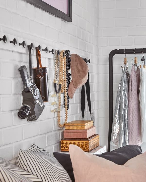 Des patères effet blanchi/anthracite équipées de boutons sont fixés au mur. Des accessoires y sont accrochés.