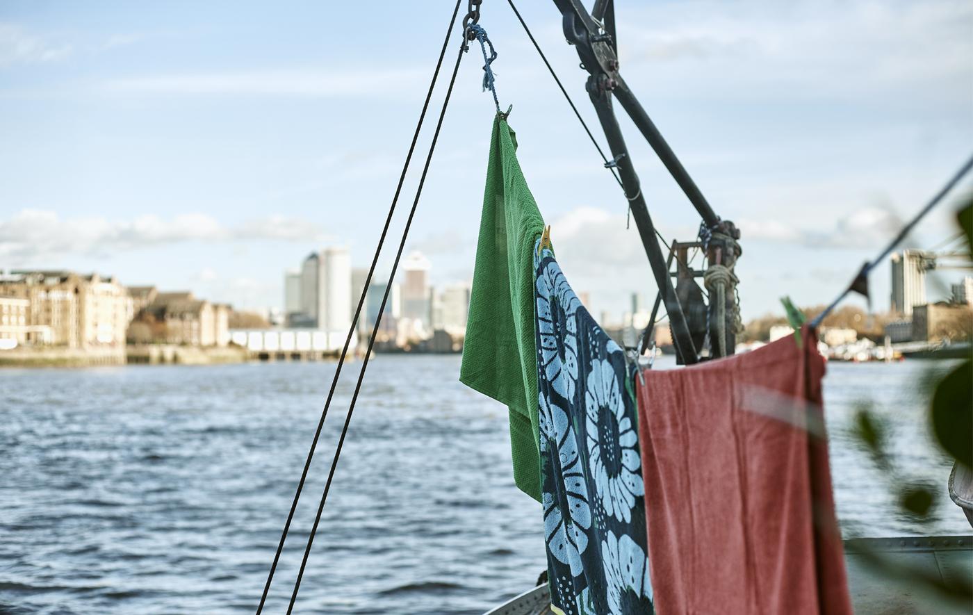 Des serviettes suspendues à une corde sur un bateau sur le fleuve.