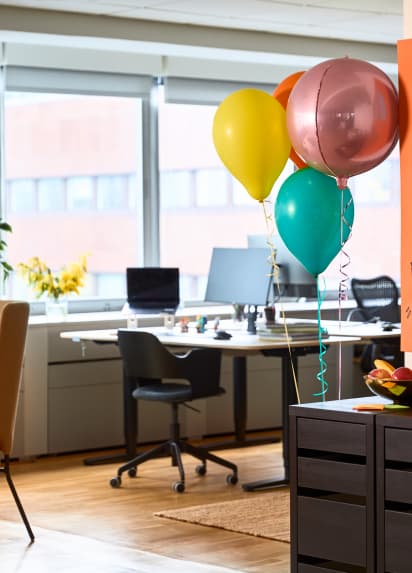 Desks in an office with balloons in the forefront