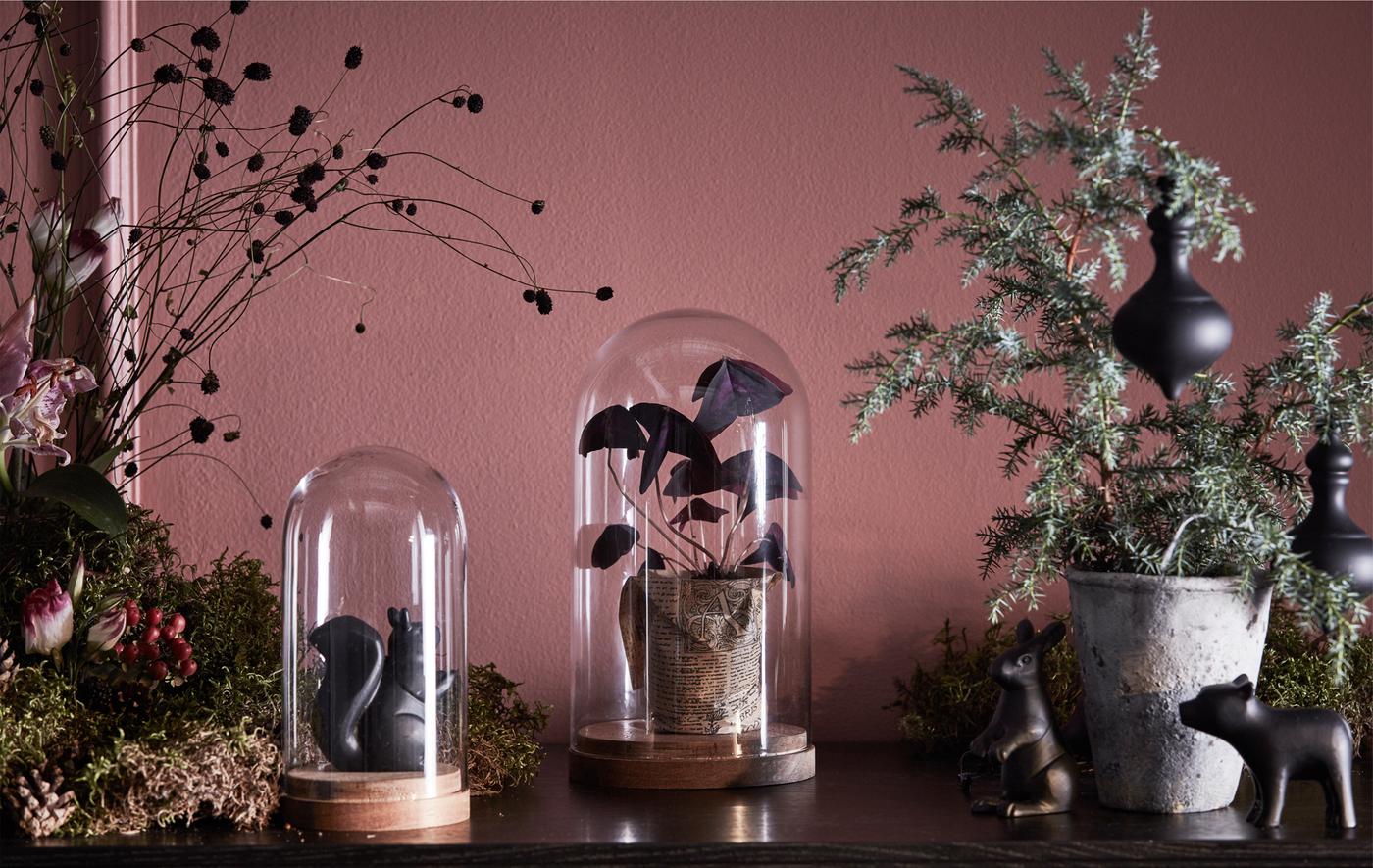 Dessus d'une vitrine décoré de verdure, de fleurs et de cloches en verre.