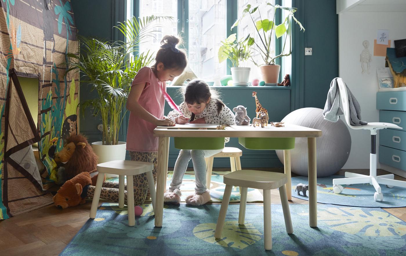 Deux enfants dessinent sur une table de jeu IKEA