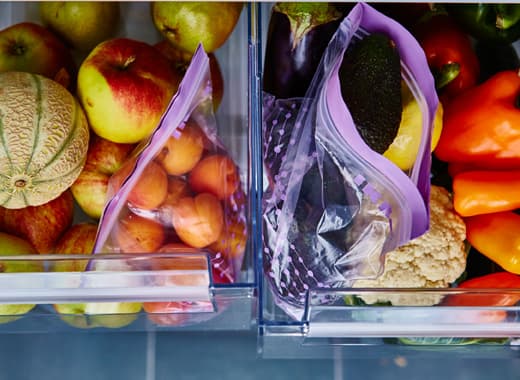 Deux tiroirs ouverts remplis de fruits et de légumes bien rangés.