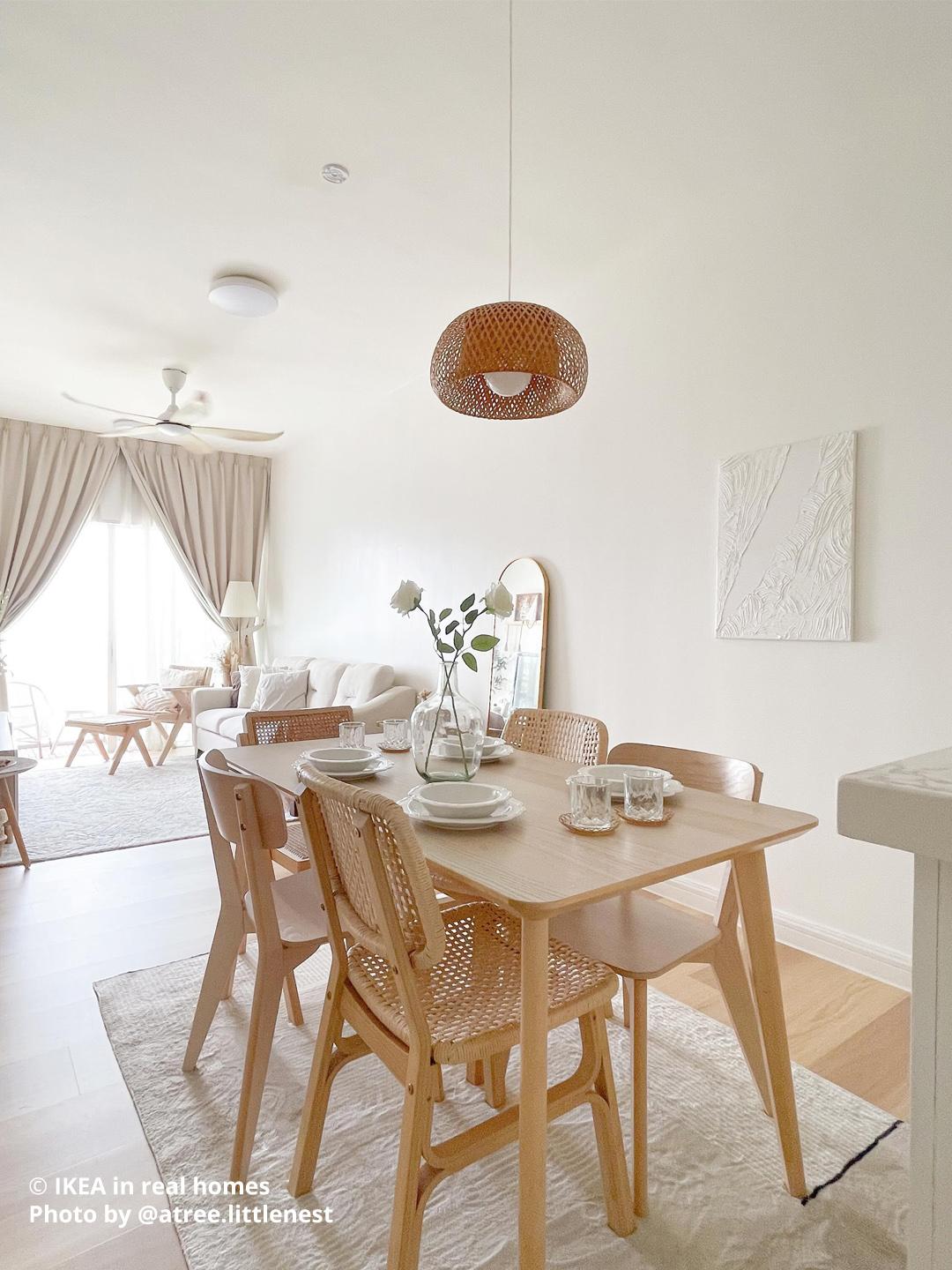 Dining room with 2 cushioned wooden chairs with dinnerware on top. There is a ceiling hanging light and vase with flowers on top of the table. Photo by instagrammer @atree.littlenest for IKEA in real homes ©