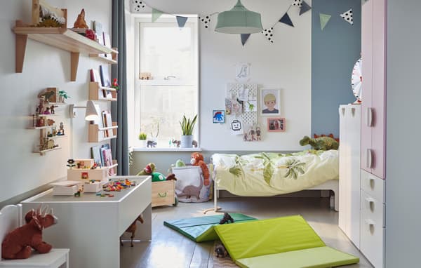 dinosaur themed children’s bedroom with wardrobe in white and light pink.