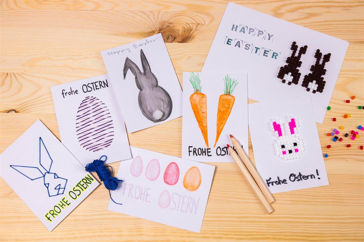 Diverses cartes de Pâques faites maison, réalisées en papier SOLFÅGEL et brodées de motifs de Pâques, dessinées à la main ou décorées de perles à repasser.