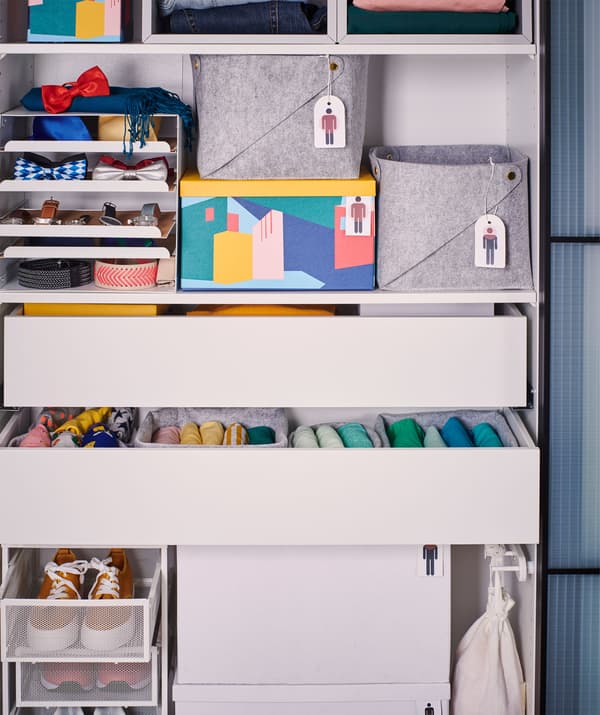 Doorless wardrobe frame filled with various drawers and boxes, in turn filled with clothes and accessories.