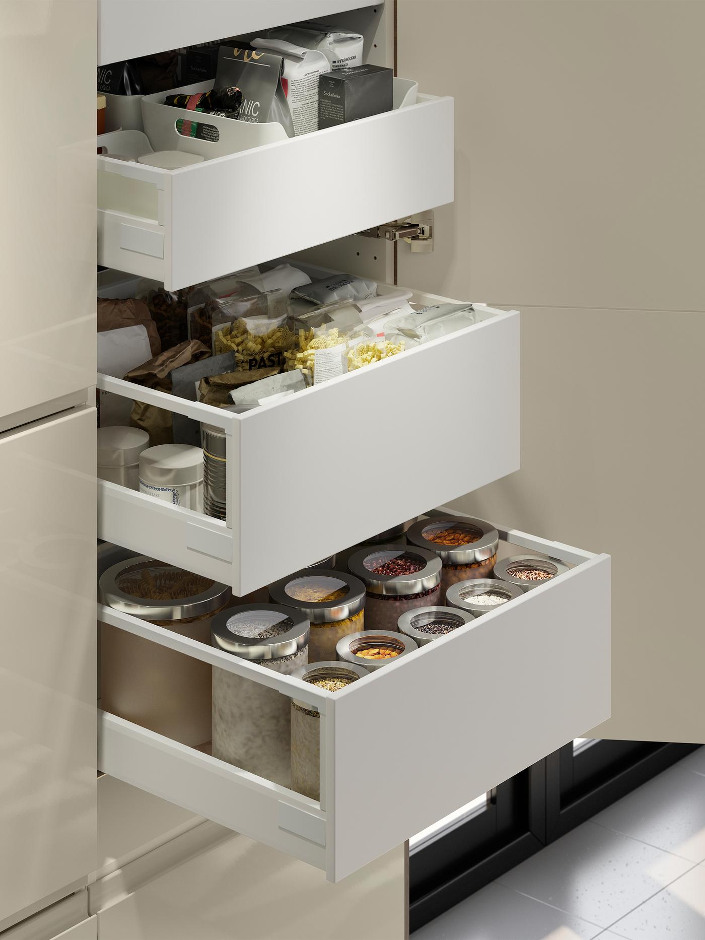 Drei Schubladen in einem Schrank, alle von ihnen ausgezogen. In den Schubladen sind Trockenvorräte zu sehen.