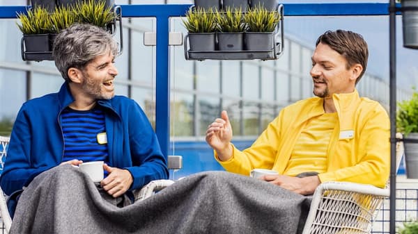 Dva zaměstnanci IKEA sedí na terase a užívají si svou pauzu.