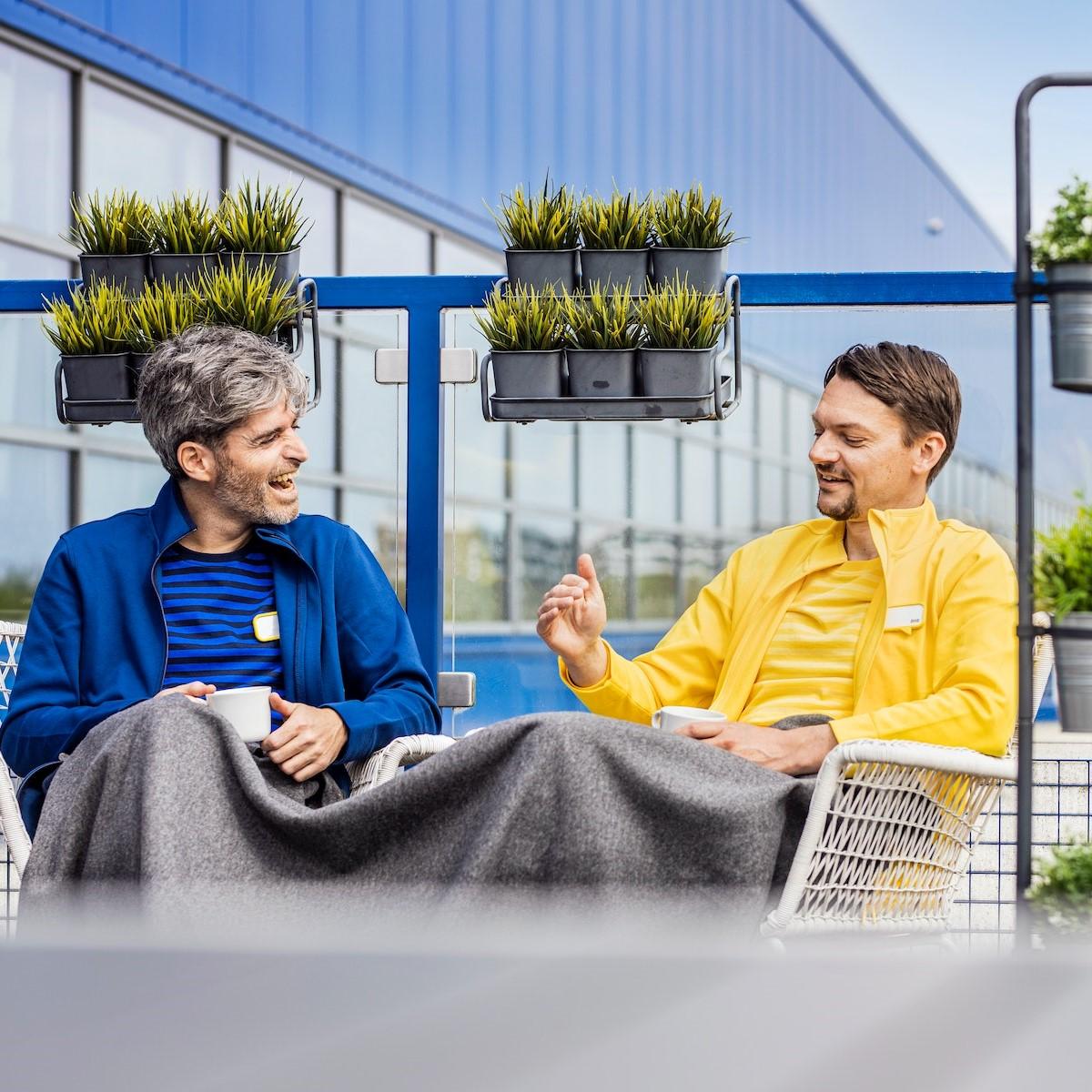 Dva zaměstnanci IKEA sedí na terase a užívají si svou pauzu.