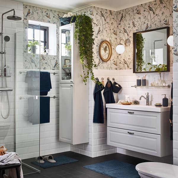 È facile creare un’atmosfera rilassante in bagno con il lavabo e il mobile con anta a vetro bianchi della serie GODMORGON e con le lampade da parete nichelate LILLHOLMEN, che diffondono una luce calda e accogliente.