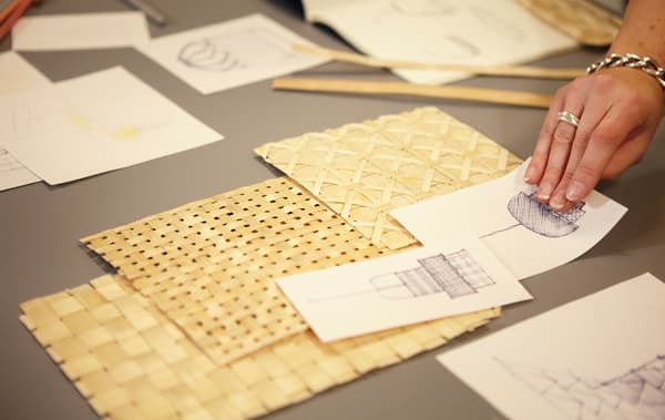 Échantillons de bambou tressé et des croquis sur une table.