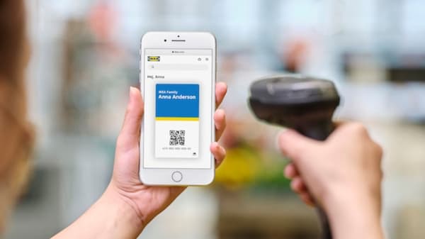 Een hand scant de IKEA Family QR-code