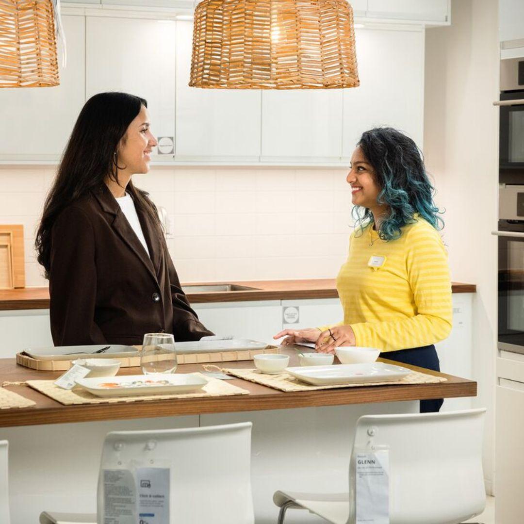 Een IKEA medewerker helpt een klant. 