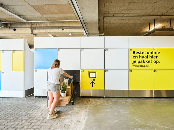 Een persoon die een pakketlockersysteem gebruikt in een modern gebouw.